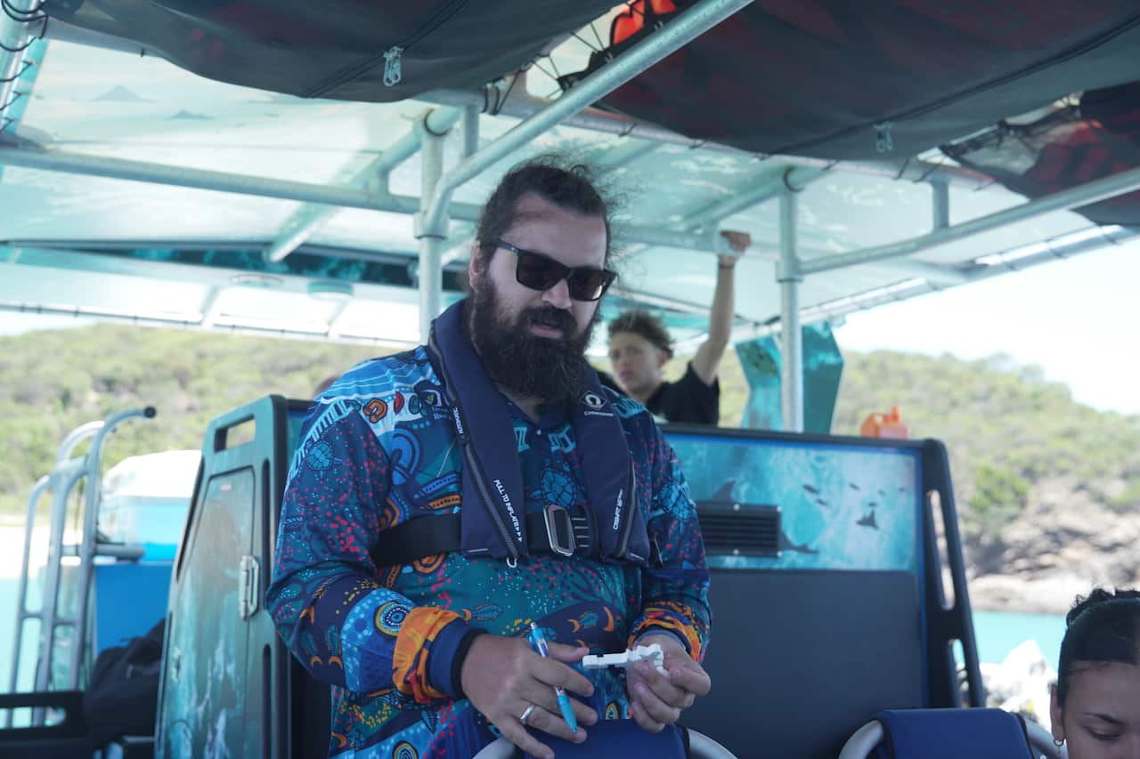 Man on boat holding white device 