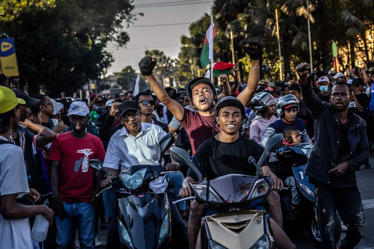 Motorcyclists drive chanting anti-government slogans and waving Malagasy flags as they celebrate