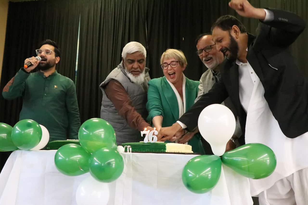 cake cutting as community in Tasmania celebrating 14 Aug