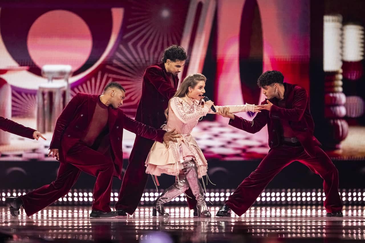 A woman and three male dancers on stage, all wearing shades of pink