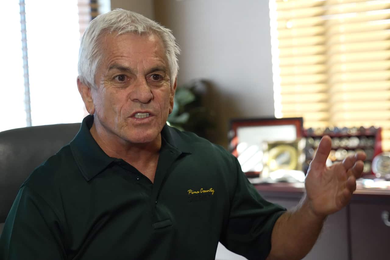 A man speaking during an interview with a journalist.