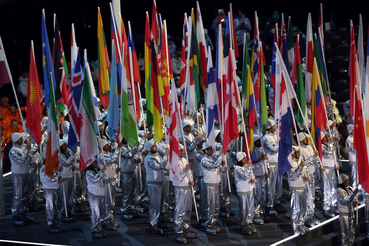 Flag bearers holding flags of dozens of different countries at the 2026 Winter Olypmics opening ceremony