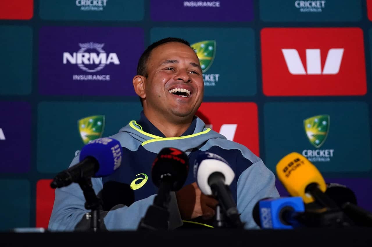 A man is laughing during a press conference.