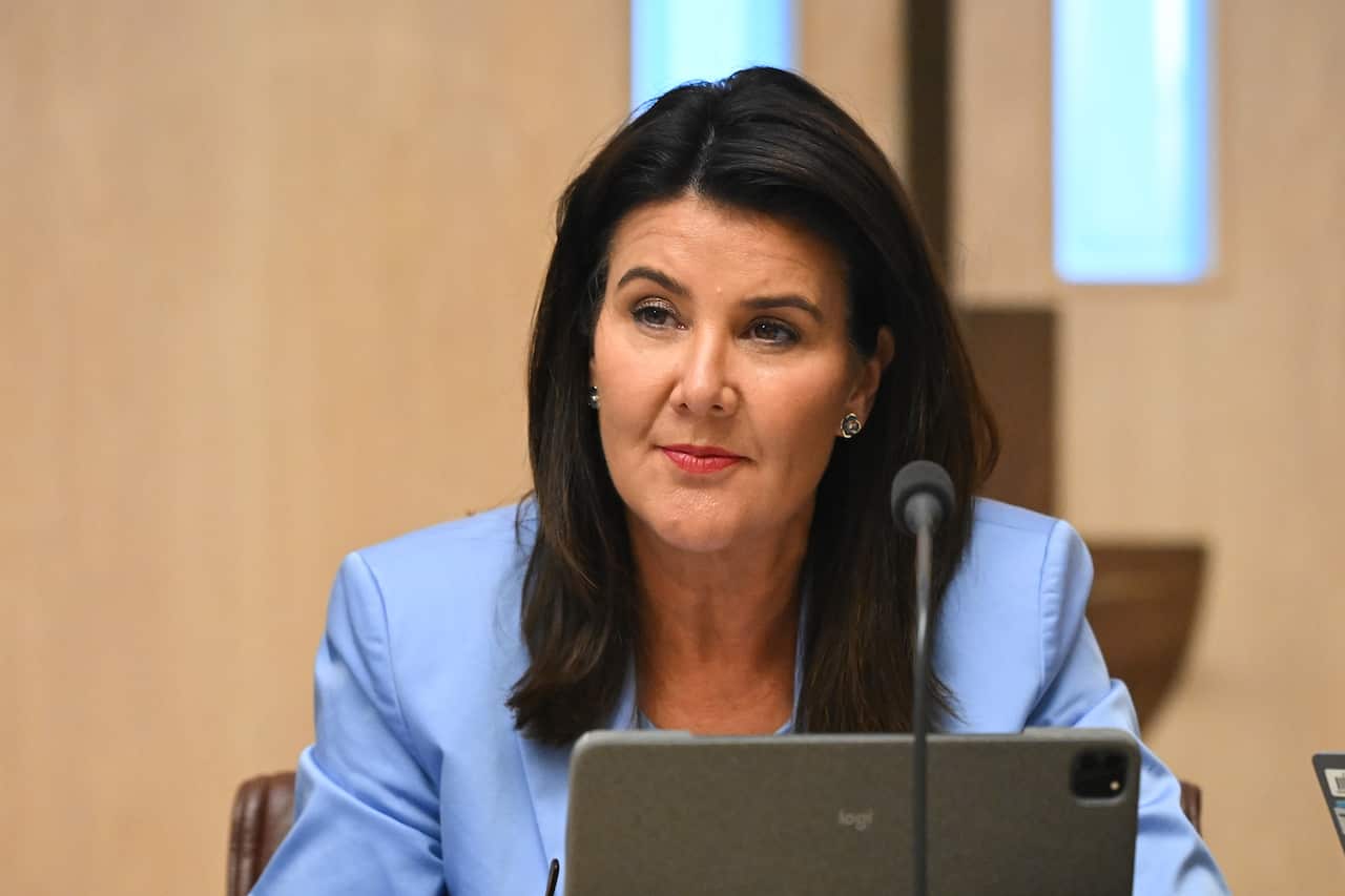 A middle-aged white woman wearing a blue suit jacket