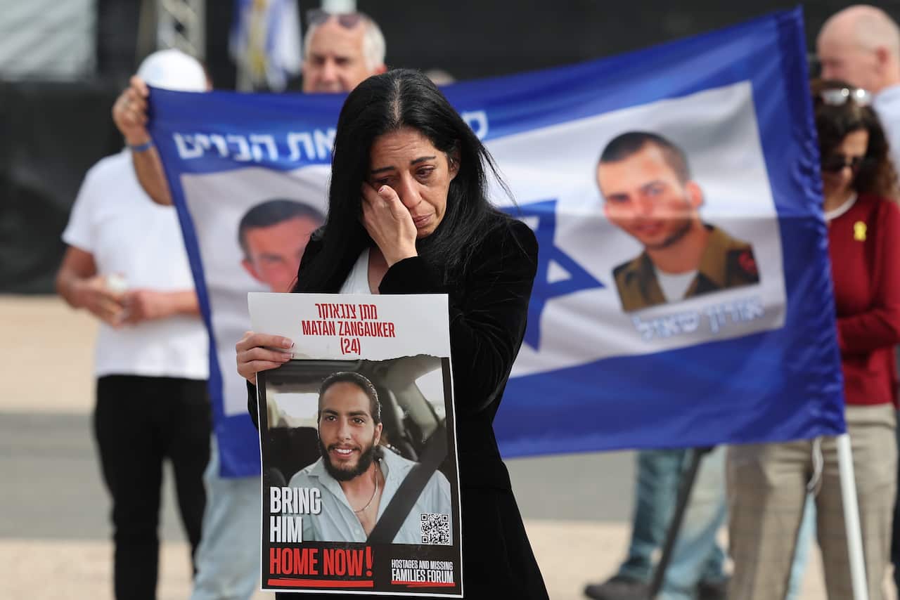 A woman crying in front of a placard