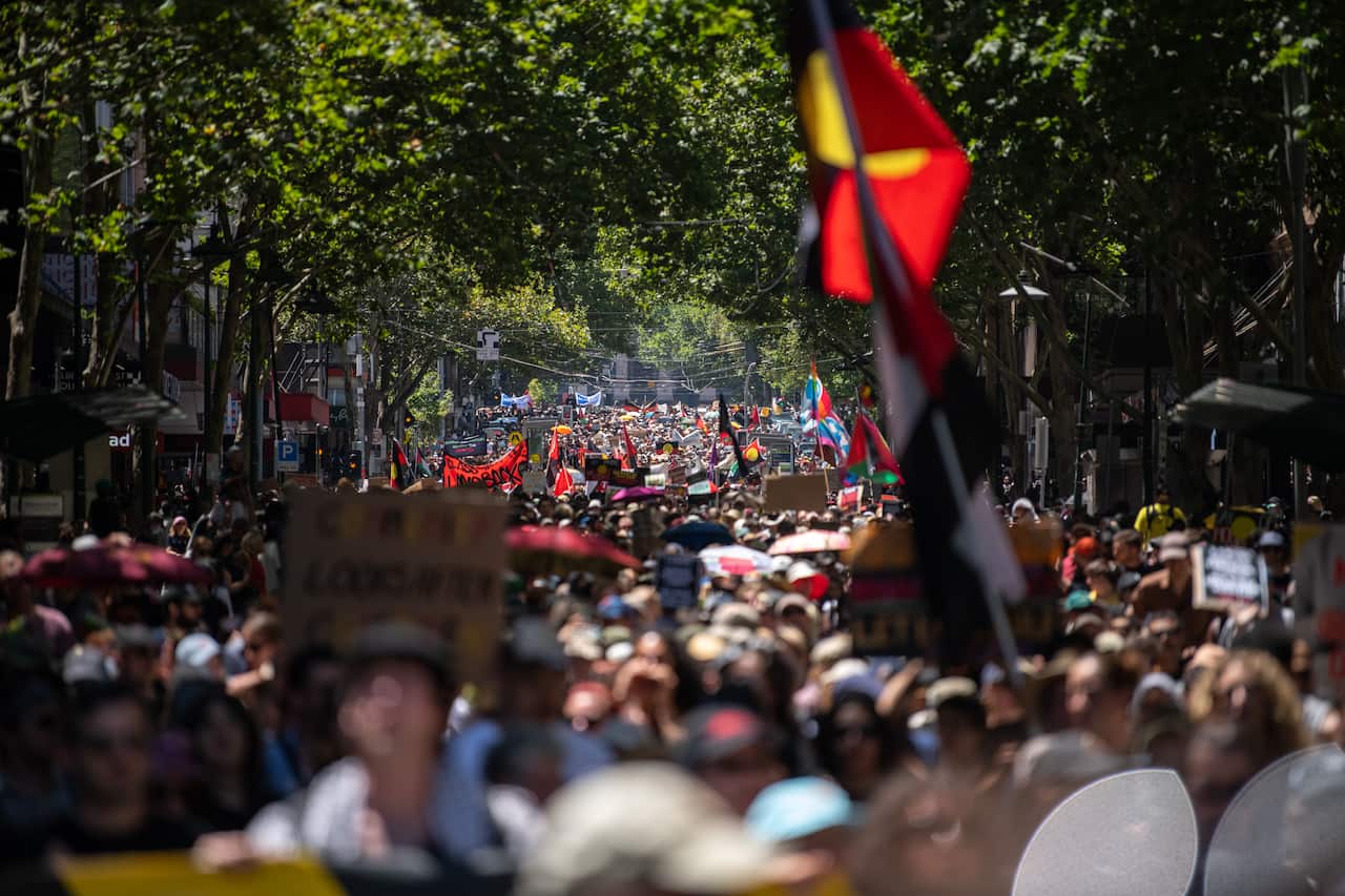 Una multitud de manifestantes, muchos de ellos con banderas aborígenes.