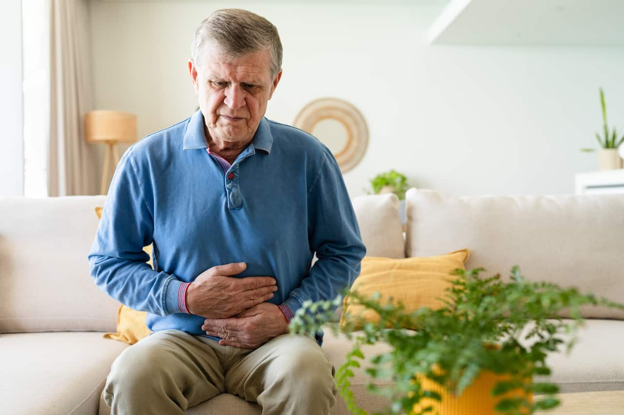 Senior man suffering stomach pain at home