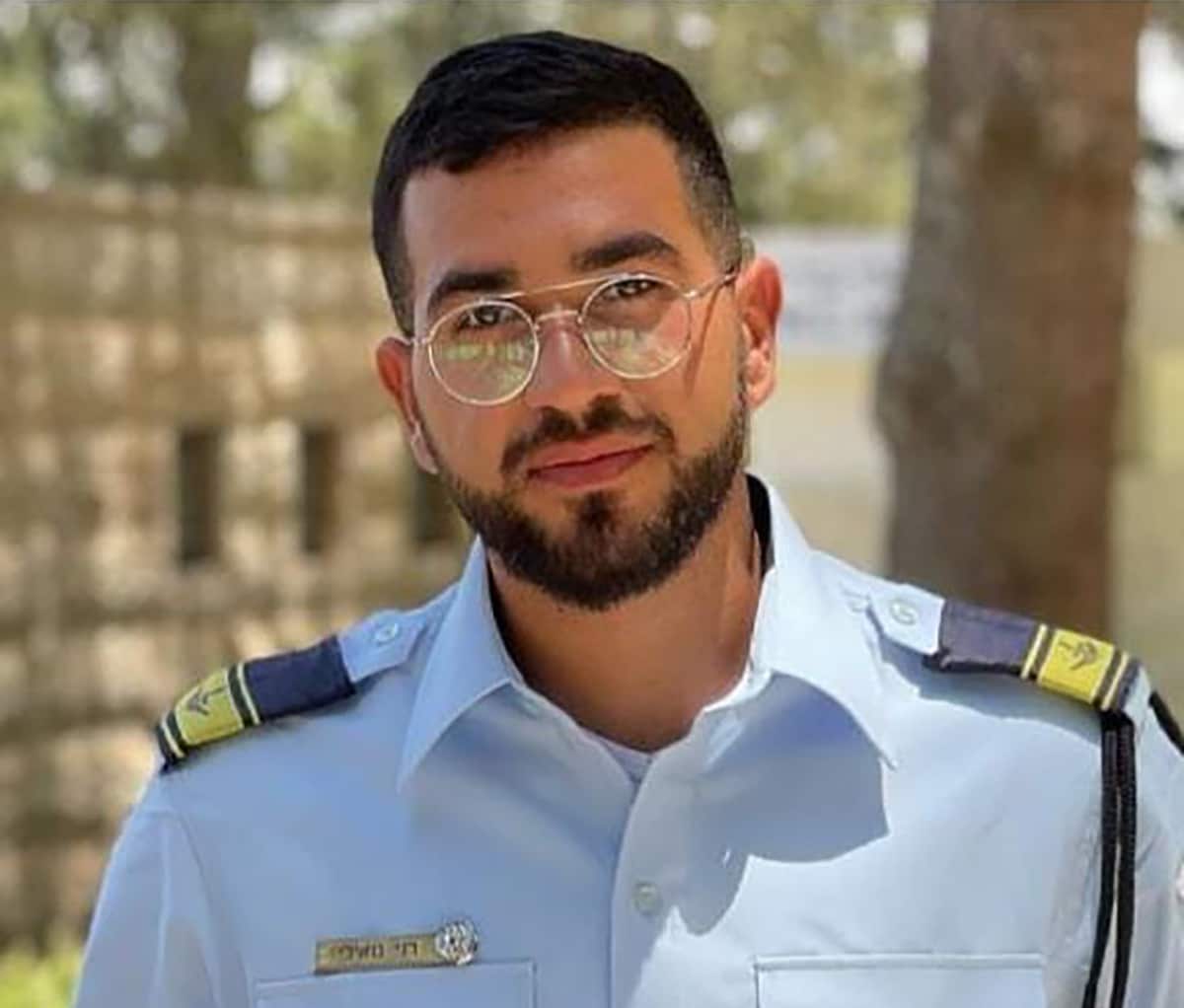 A young man with black hair and glasses wearing a blue uniform
