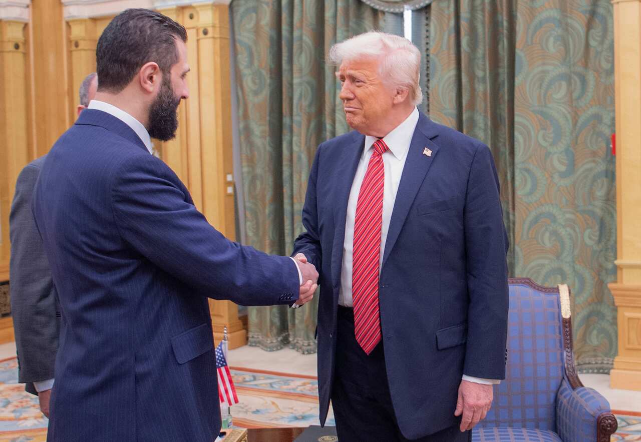Two men in suits shake hands