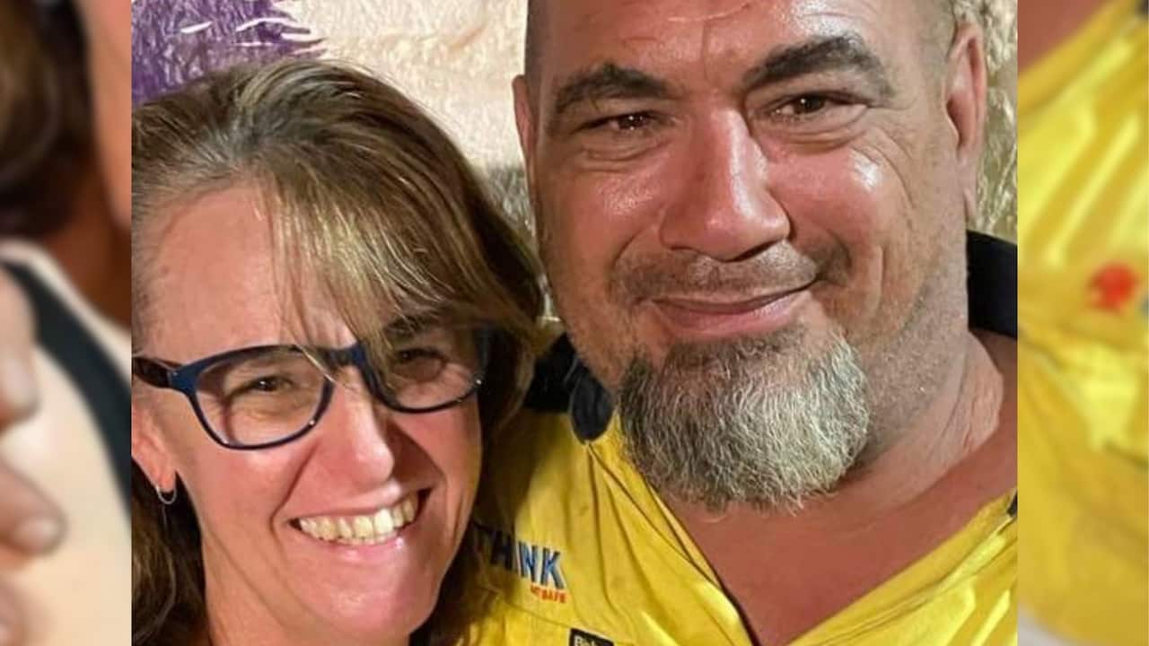 a closeup of a middle aged couple: a woman with blonde fringe and glasses and a bald man with a grey beard