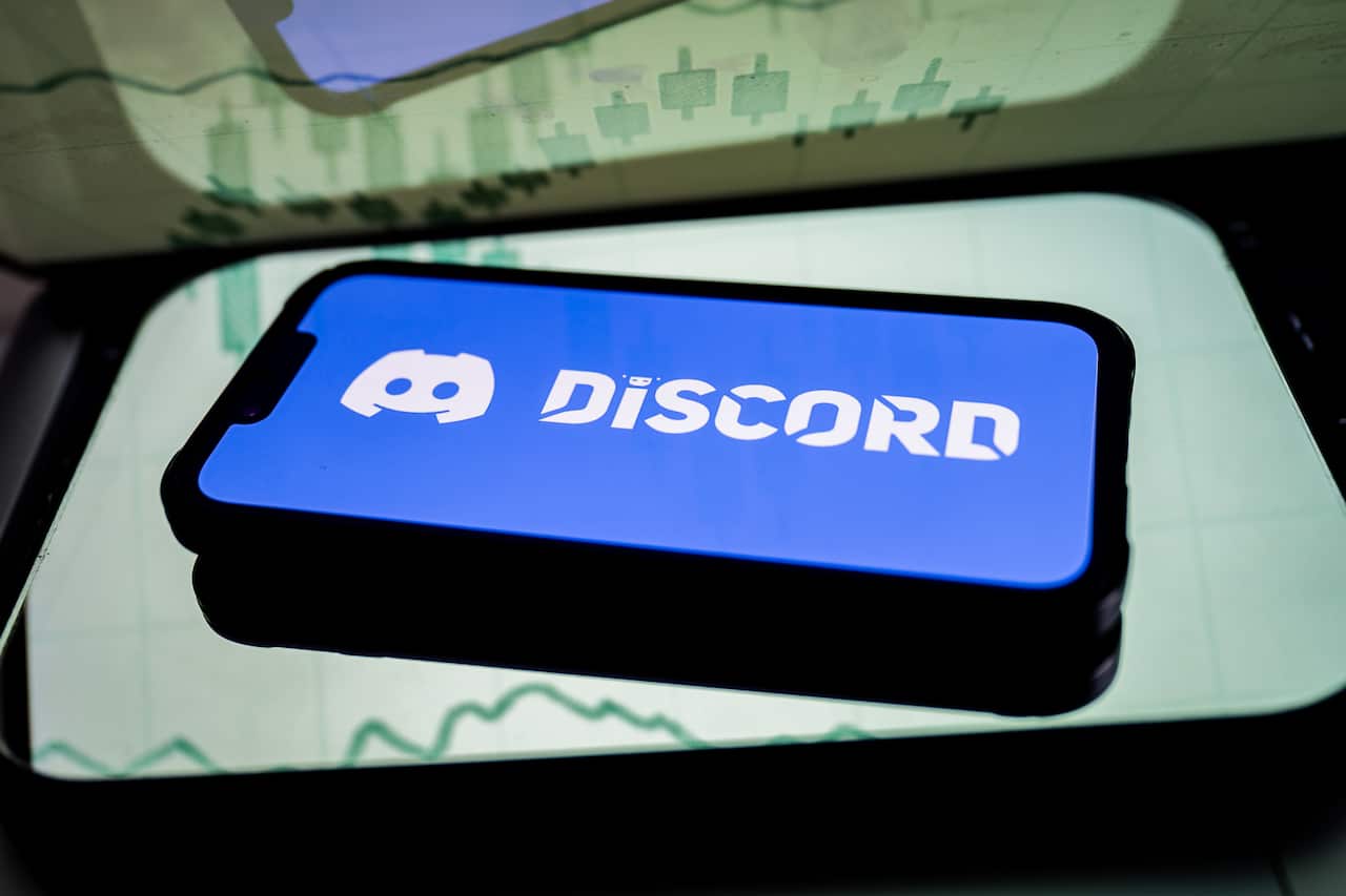 A smartphone with a purple and white discord logo displayed on the screen.