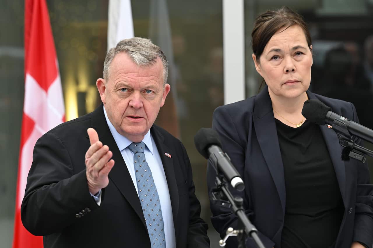 A man and a woman wearing suits holding a press conference