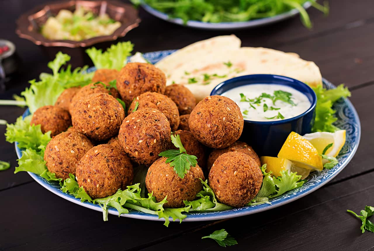 Falafel, hummus and pita. Middle eastern or arabic dishes on a dark background. Halal food.