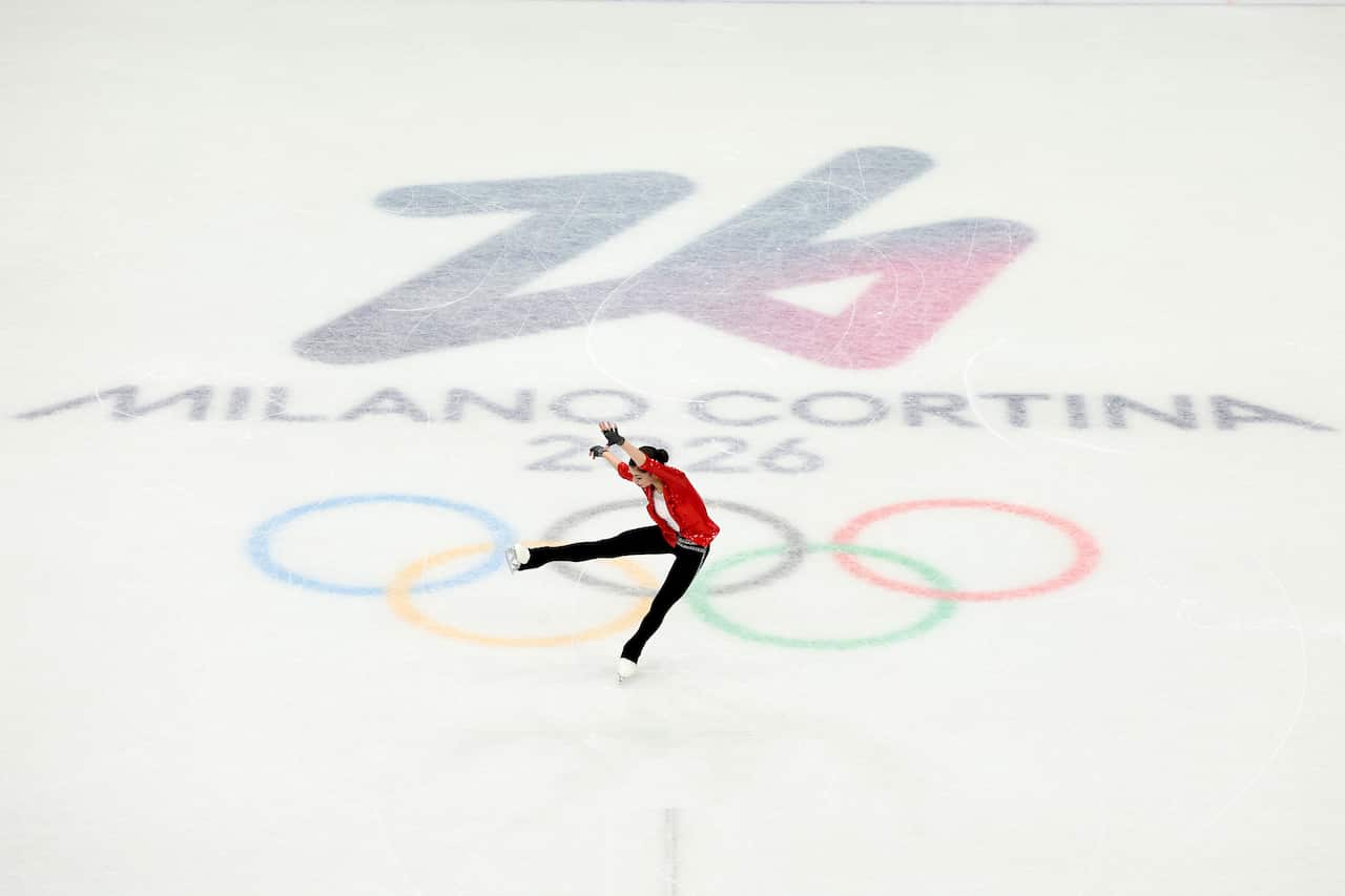 A figure skater on ice that bears the Milano Cortina 2026 logo