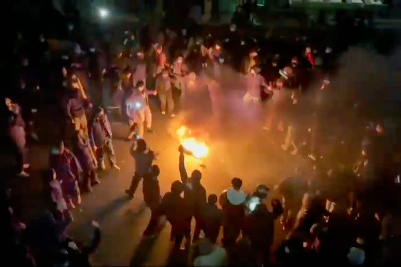 Protesters dancing and cheering around a bonfire as they take to the streets in Iran 