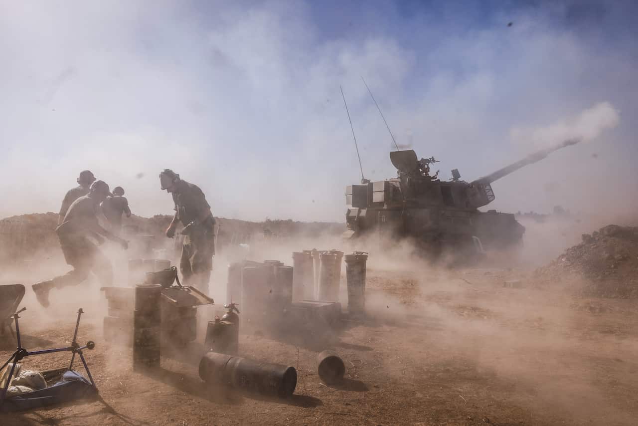 Three soldiers standing near a tank.