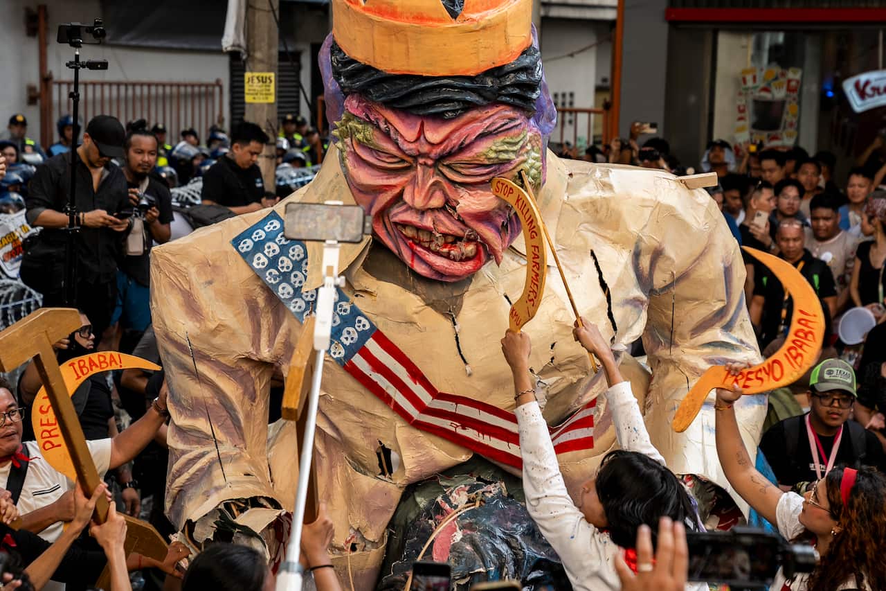 Protesters destroy an effigy depicting Philippine President Ferdinand Marcos Jr during a rally.