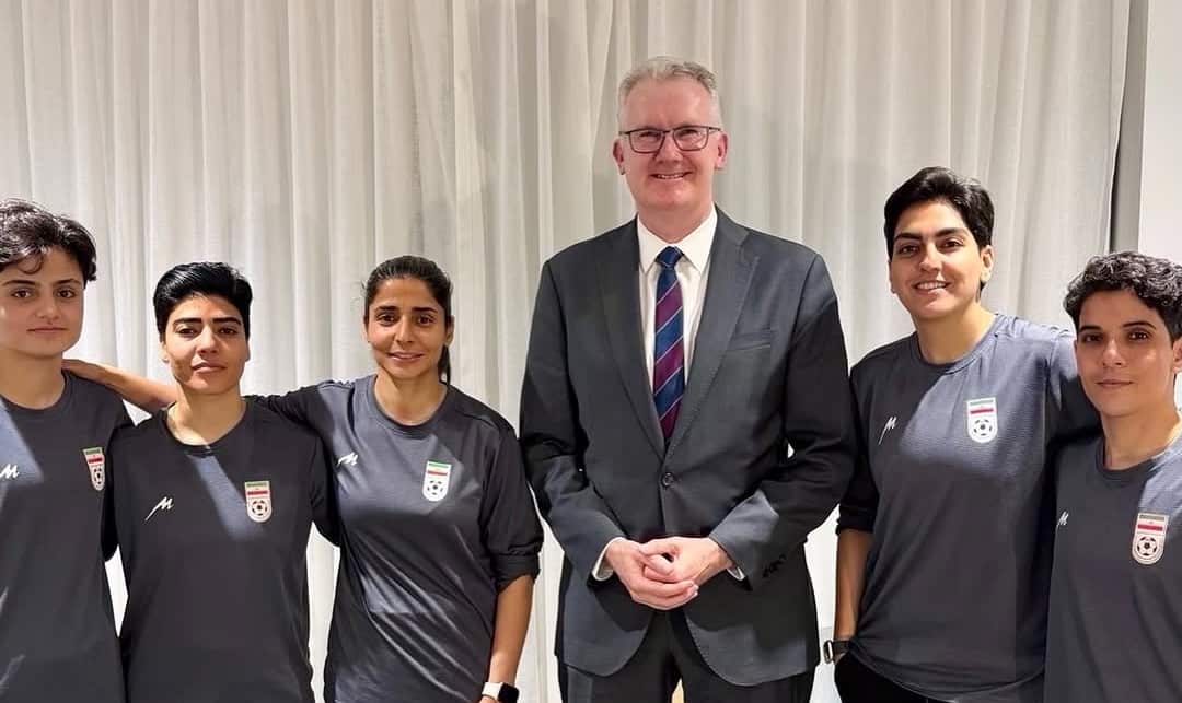 Tony Burke standing next to five women, wearing shirts with the Iranian flag and a football.