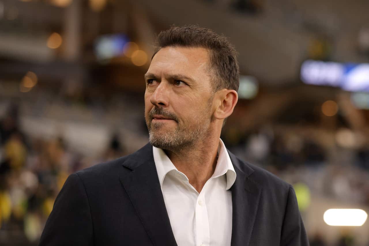 Tony Popovic in a dark suit and white shirt