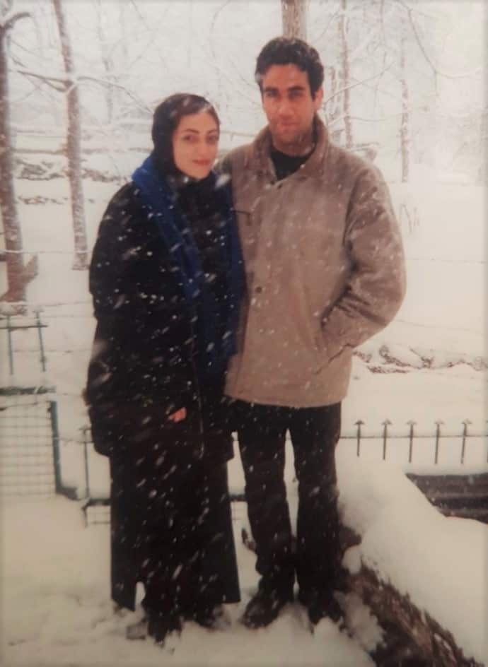 Marta standing in a long jacket in the snow with her husband in Iran