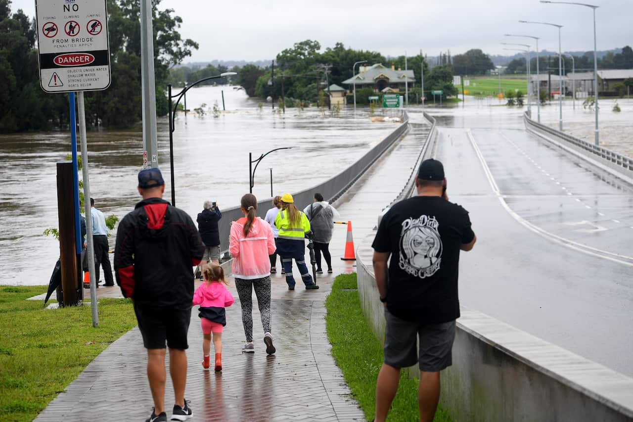 Onlookers watch on as the Windsor Bridge is impacted by floodwater from the Hawkesbury river at Windsor. 