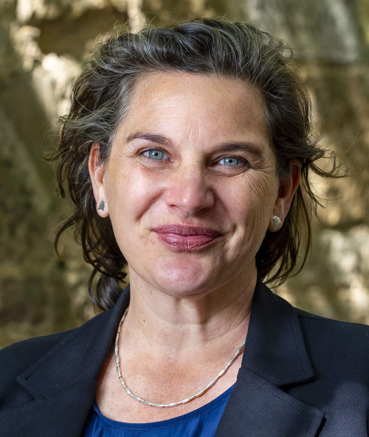 A smiling woman wearing a blazer.
