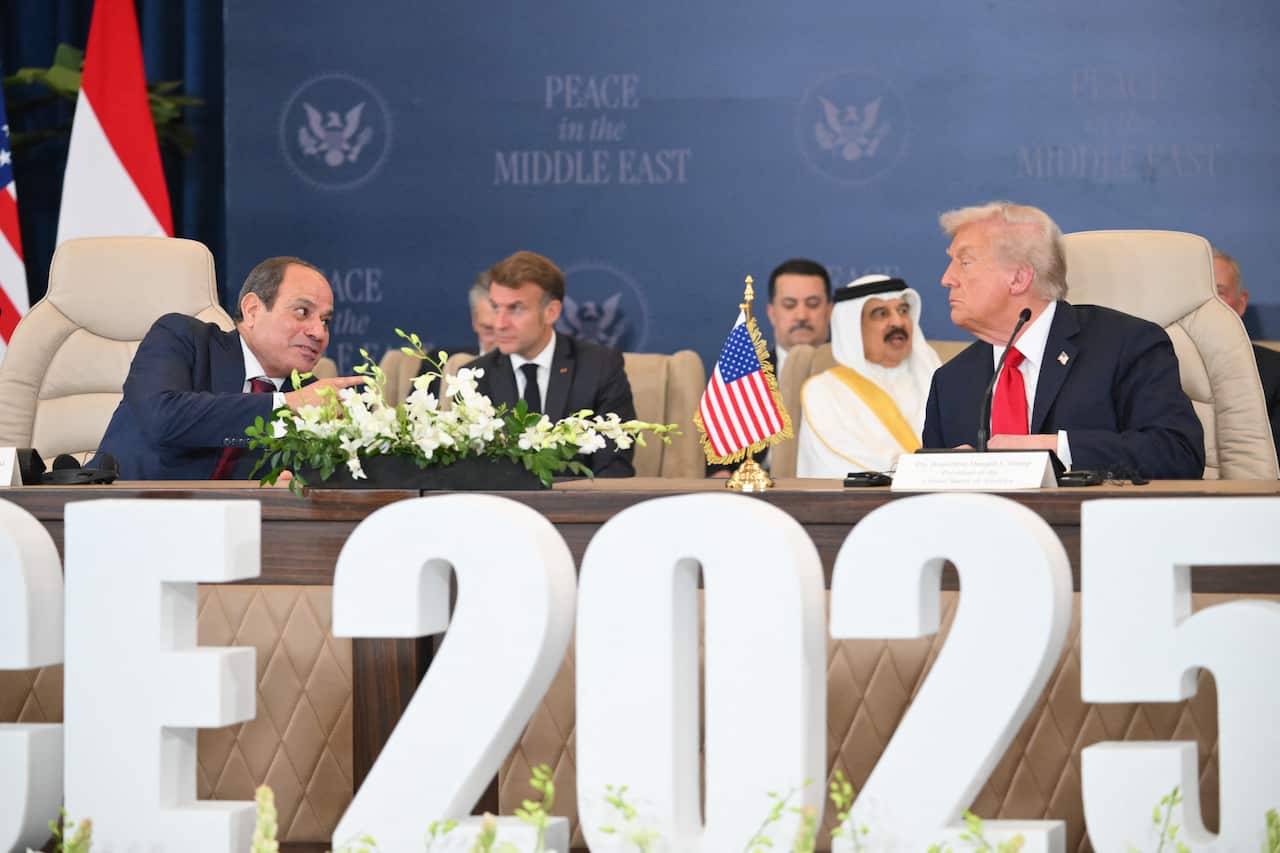 A group of men sitting on a long table.