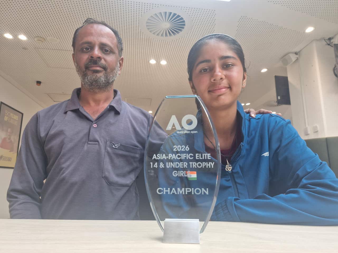 Tennis player Jensi Kanabar (R) pose with the trophy with her father, Dipak Kanabar (L)
