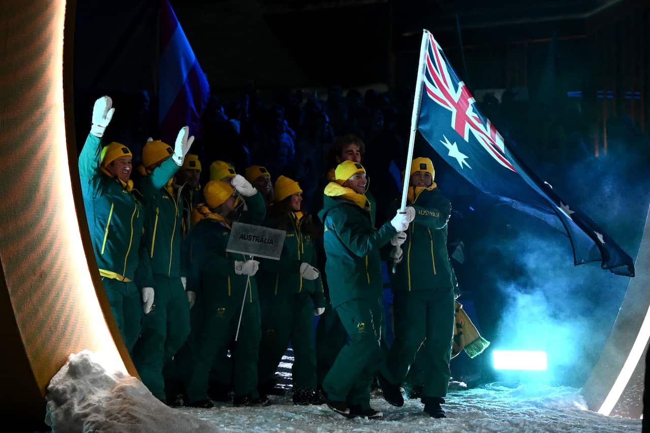 The Australian contingent at the 2026 Winter Olympics opening ceremony wearing green and gold and carrying an Australian flag