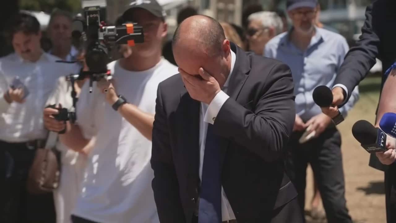 Former Liberal MP Josh Frydenberg holds his hand over 