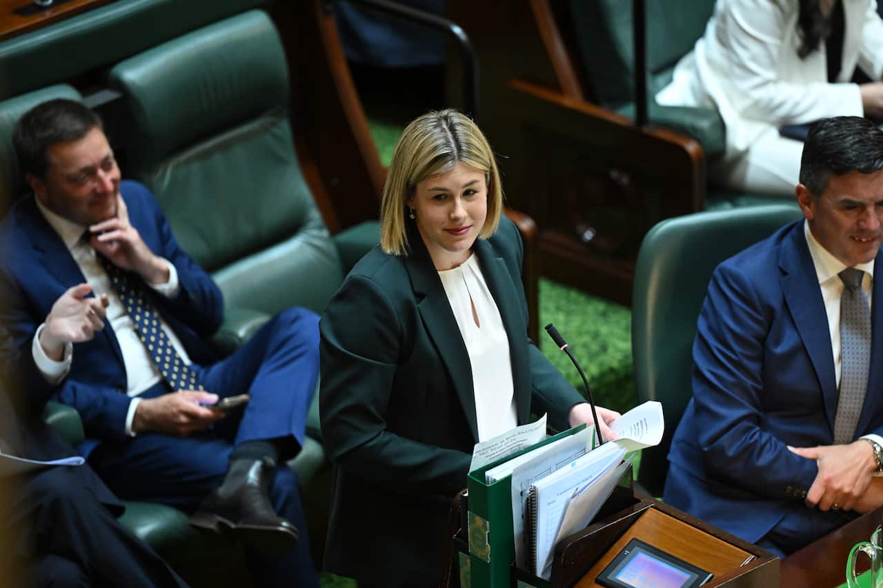 Woman stands in front of microphone in green room