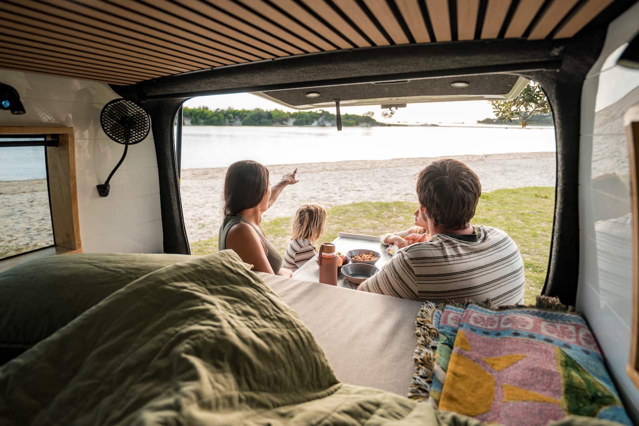 Young Family Enjoying Outdoor Meal in Sunlit Minivan