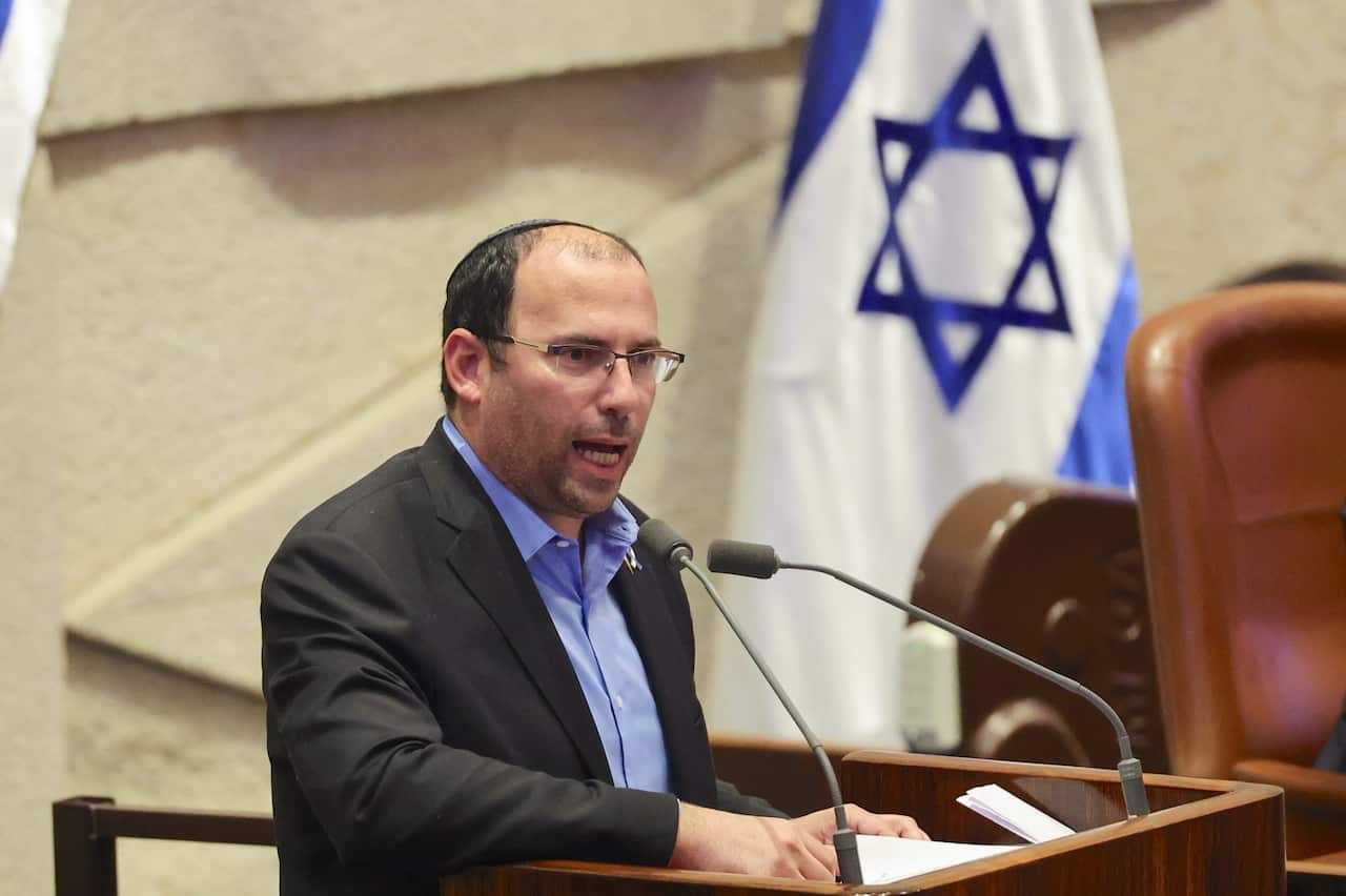 Simcha Rothman speaking at podium