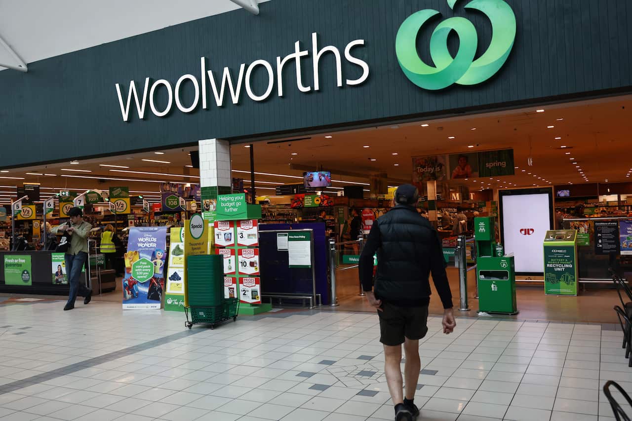 People walking in and out of a Woolworths supermarket.