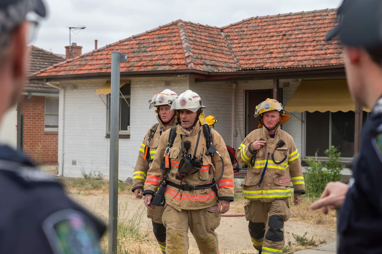 Metropolitan Fire Service Firefighters in the front of the fire site house.