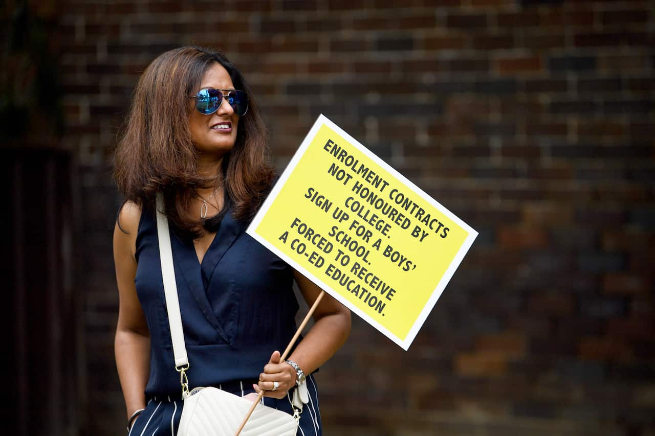 A woman holds a yellow placard during a protest.