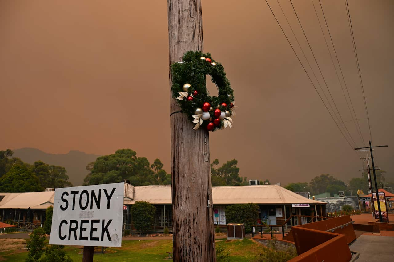 A wreath is hung on an electricity pole. A sign below it reads 'Stony Creek'.