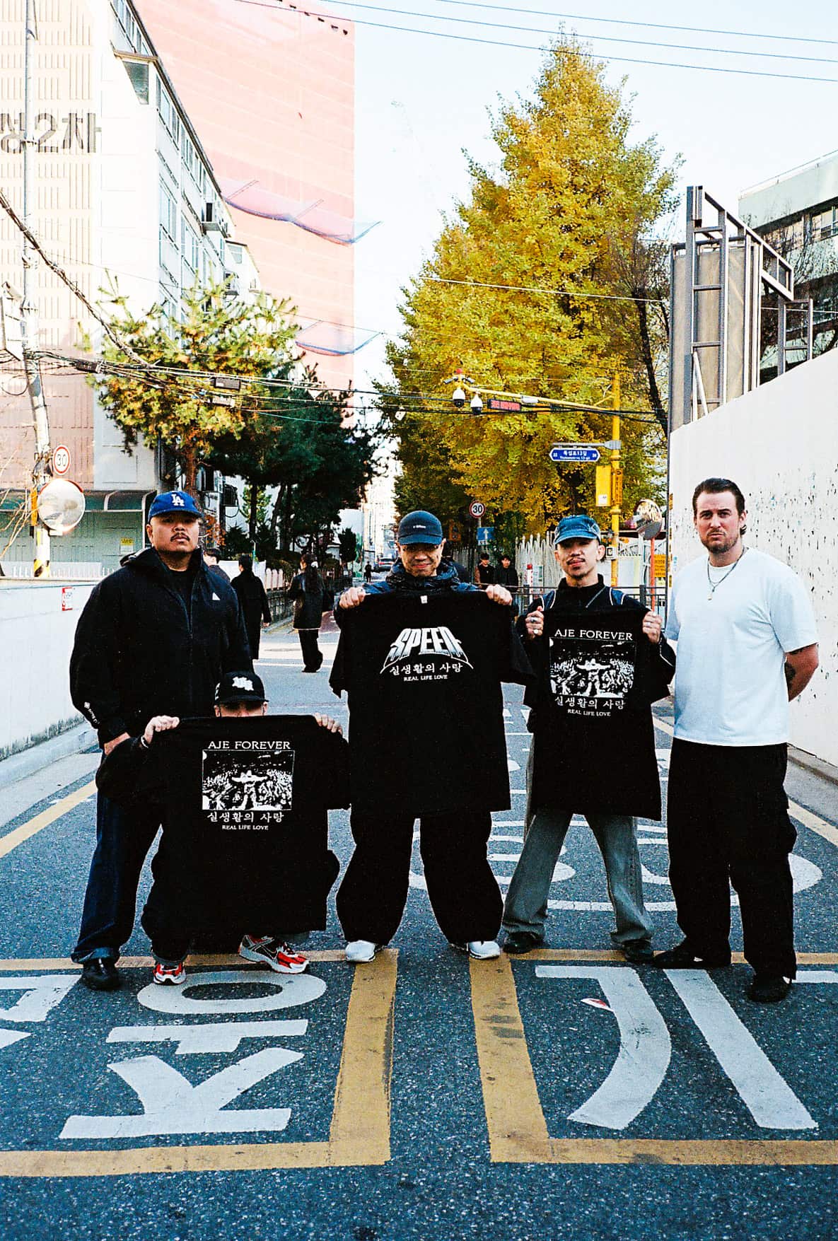 A group of men on a street holding shirts.