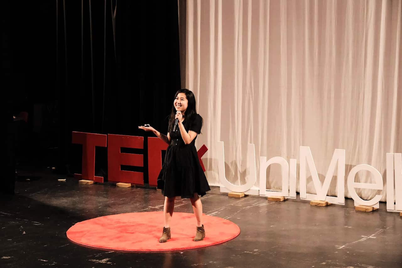 A woman giving a talk on a stage. 