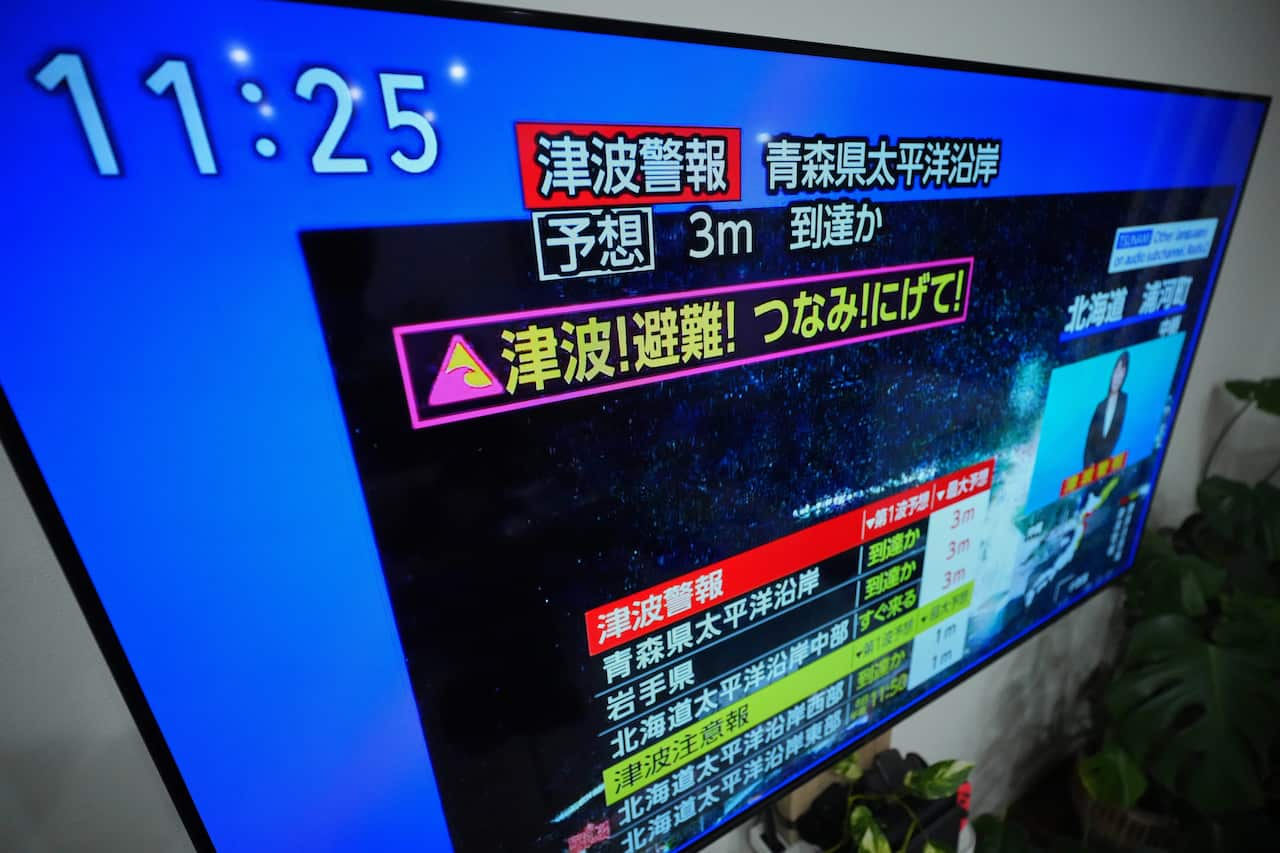 A tsunami warning is displayed on a television in Yokohama, near Tokyo, Monday, Dec. 8, 2025, after a strong earthquake hits off Japanese northern coast, tsunami alert issued.