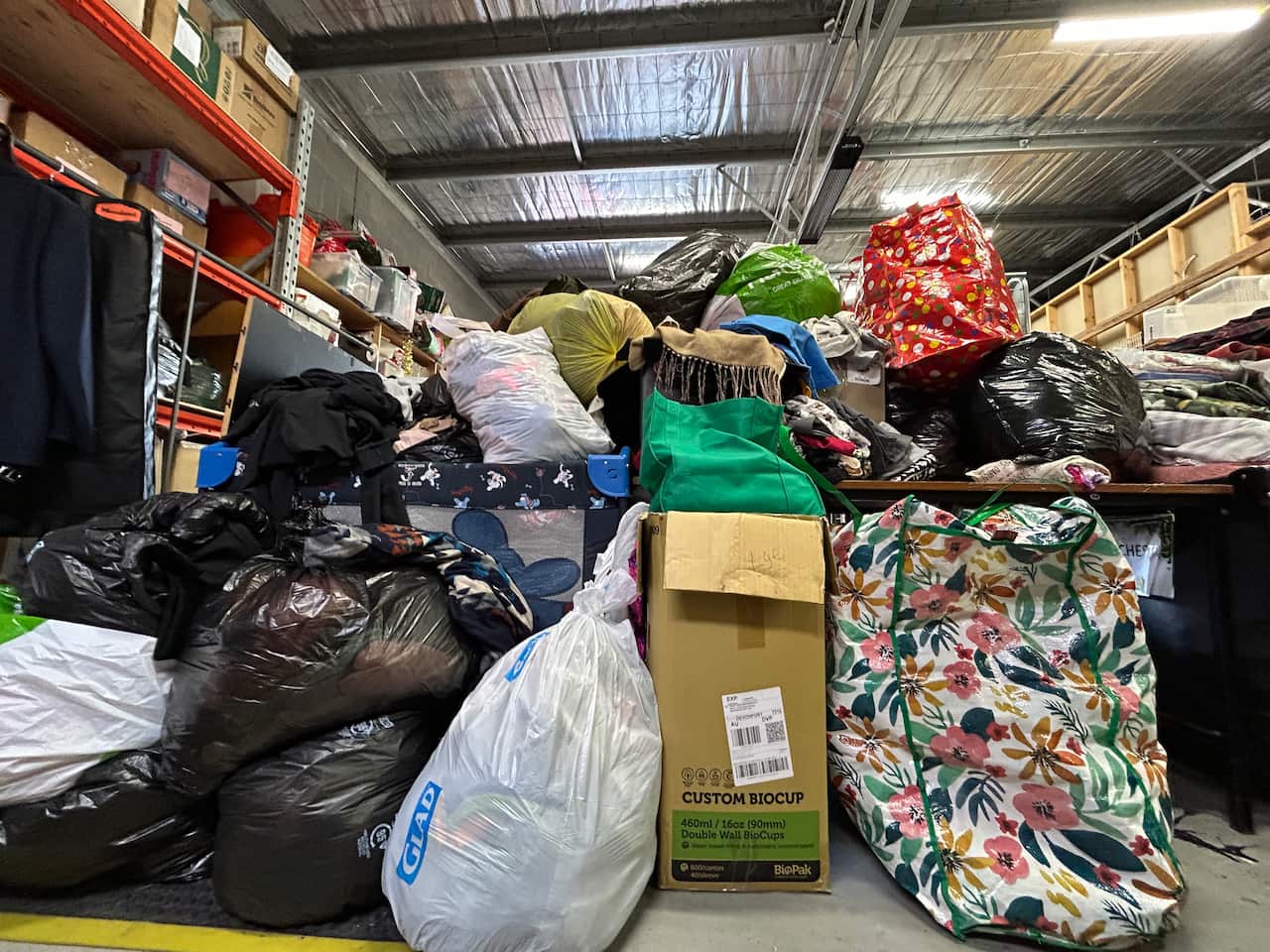 A pile of bin bags, cardboard boxes and other bags with clothing