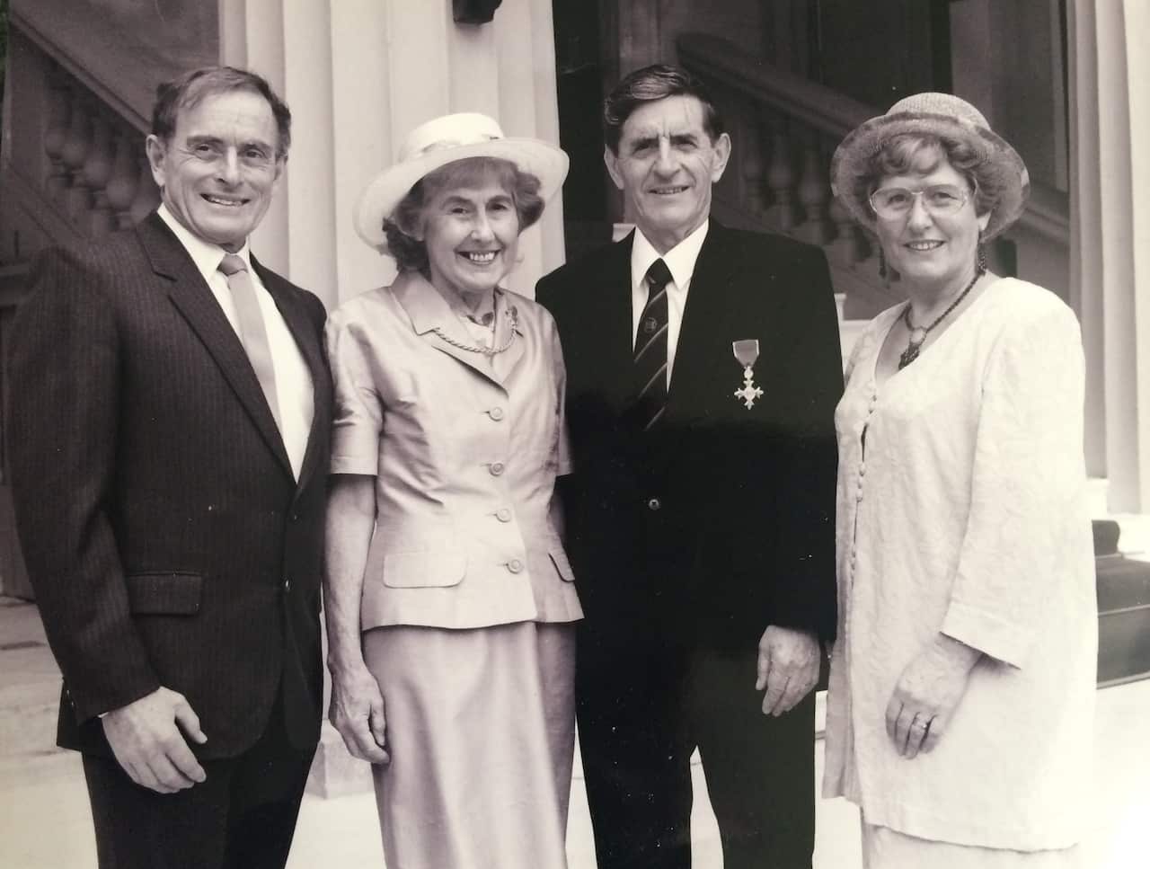 Una fotografía en blanco y negro de dos parejas vestidas de forma formal. 