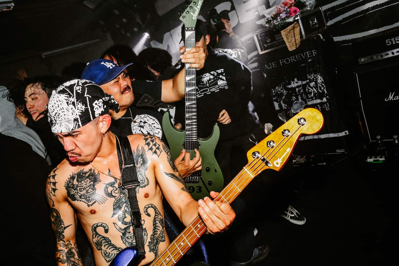 A group of people playing the guitar on stage.