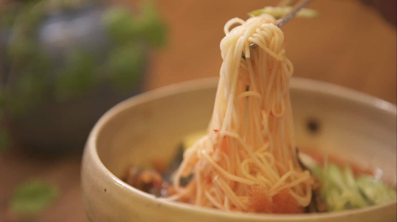 筷子把面条从碗里夹出来。