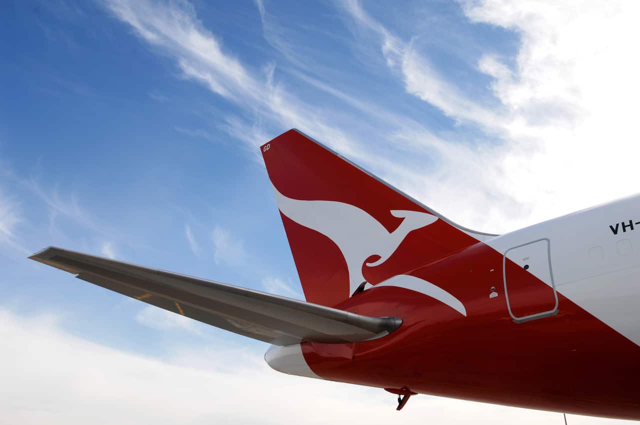 The tail of a Qantas plane with blue sky in the background