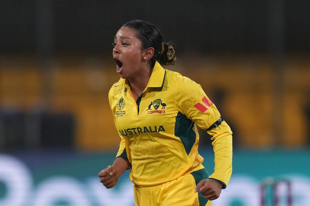 A woman wearing the Australian team's uniform is cheering during a match.