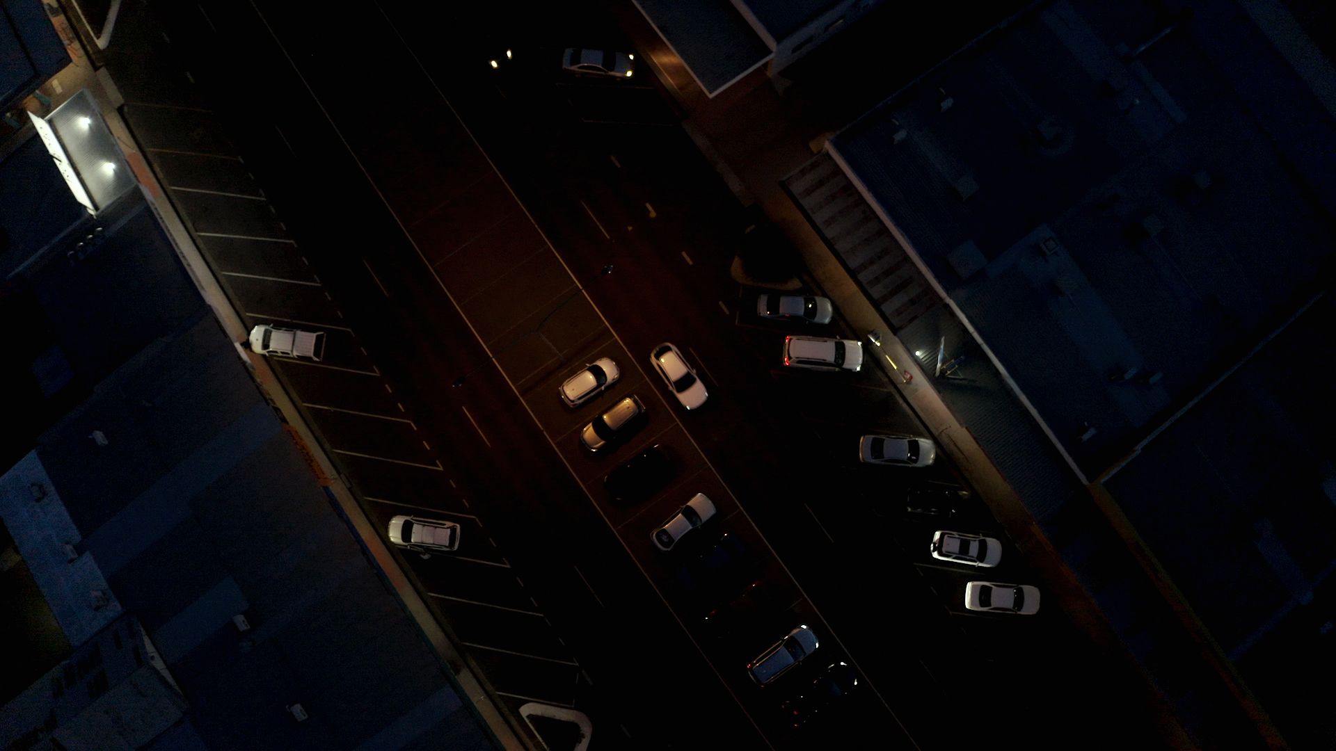 Image of a North Queensland street at night, shot from above, looking down onto rooves of cars.