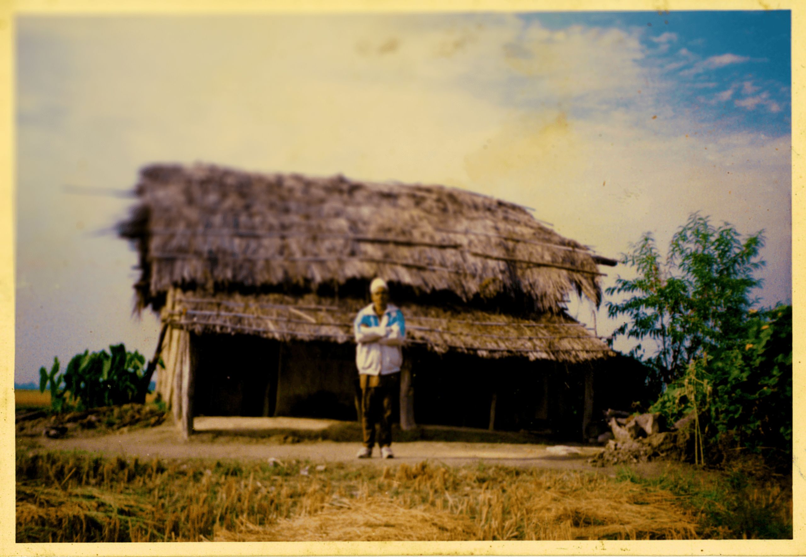 Dhital's father outside their family home circa 1990