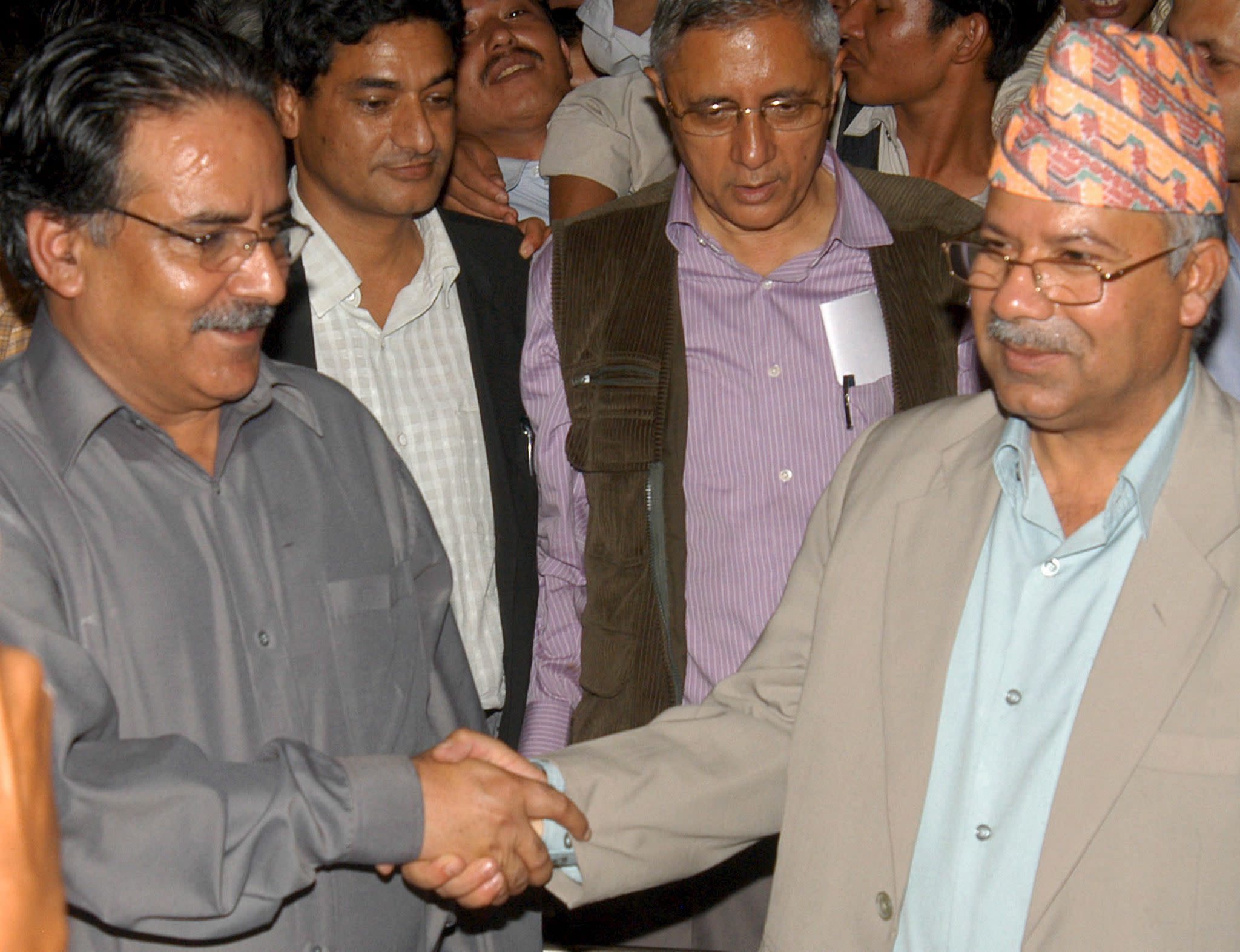 Maoist rebel chief Prachanda (L) shakes hand with Madhav Nepal (R), senior leader of the seven parties alliance after peace talks with Prime Minister Girija Prasad Koirala at the Prime Minister's residence at Baluwatar in Kathmandu on Friday. 16 June 2006. Nepal's government agreed on Friday to dissolve parliament and set up an interim administration including Maoist rebels after 11 hours talks. AAP/EPA/NARENDRA SHRESTHA