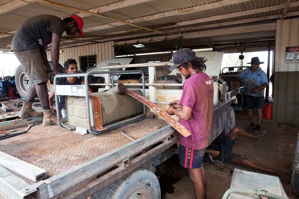 Oscar supervises his team of young men as they fix one of the bull buggies. Oscar supervises his team of young men as they fix one of the bull buggies.